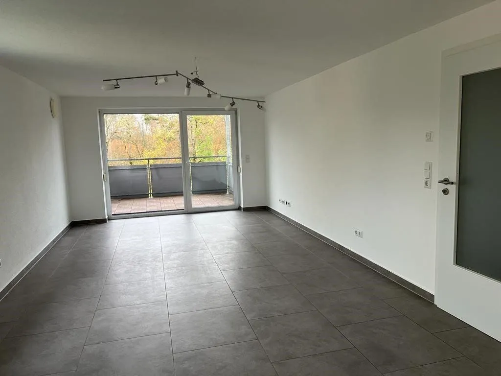 Zimmer mit Fliesenboden und Zugang zum Balkon